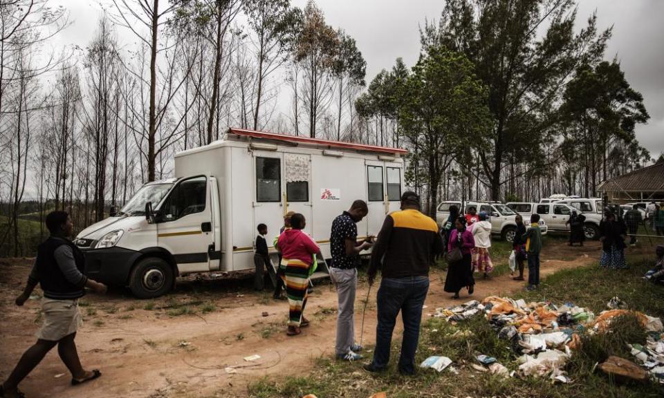 People walk by a Doctors Without Borders HIV testing mobile clinic in Ngudwini, on the outskirts of Eshowe in South Africa, in 2014.