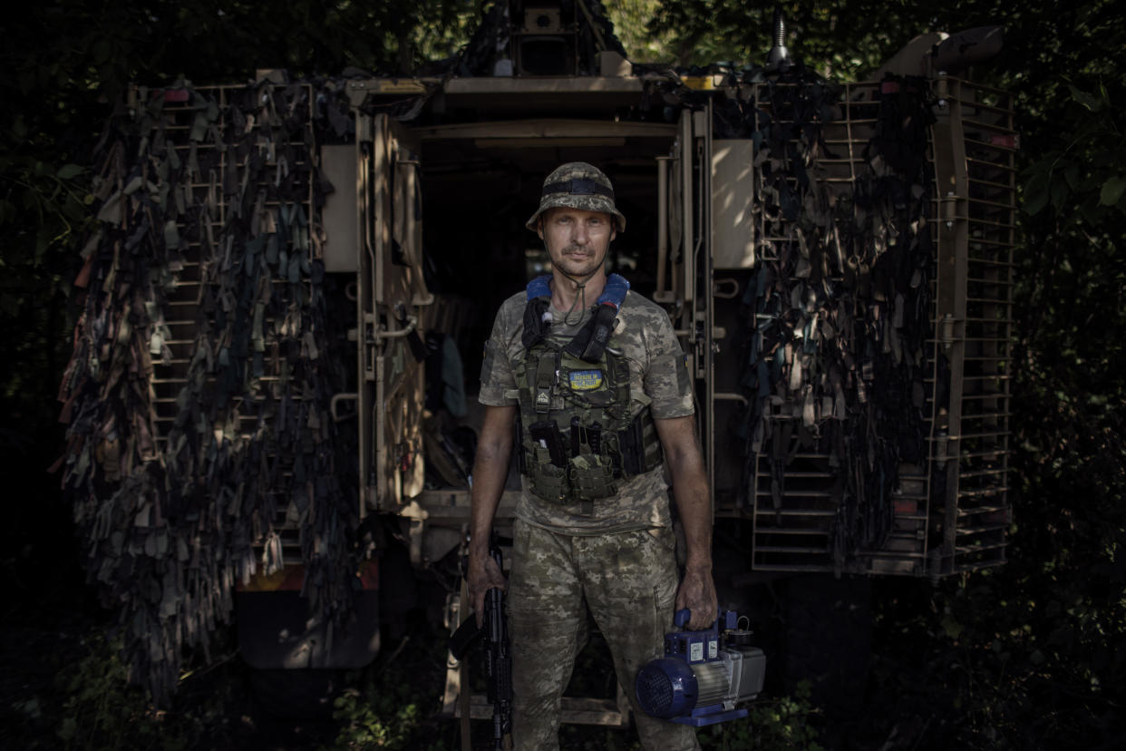 Miembros de la Trigésima Séptima Brigada de Marina se preparan para remplazar el blindaje de un vehículo de soporte táctico en un taller en la región de Donetsk, en el sur de Ucrania, el 29 de julio de 2023. (Diego Ibarra Sanchez/The New York Times)
