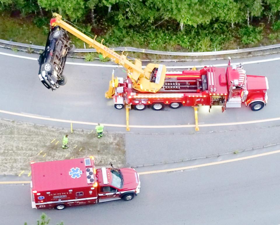 A crane is used to remove a car that was involved in a multi-vehicle crash on Route 6 in Dennis early Sunday morning. The highway was closed for a few hours while police cleared the scene.