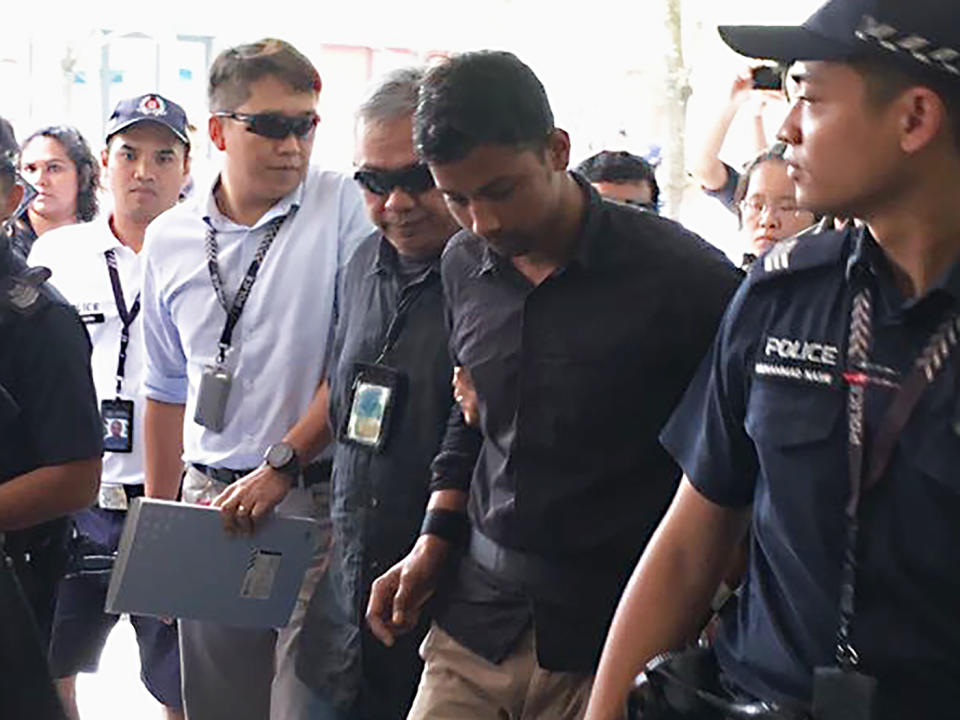 Sheikh Md Razan, being escorted by police back to the crime scene on 2 August 2018. (Yahoo News Singapore file photo)