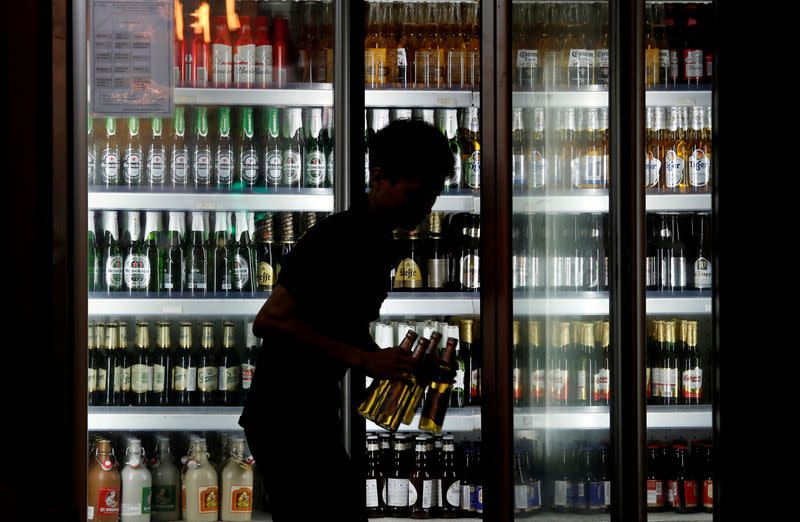 FILE PHOTO: A man takes bottles of tiger beer out of a beer fridge at a restaurant in Hanoi