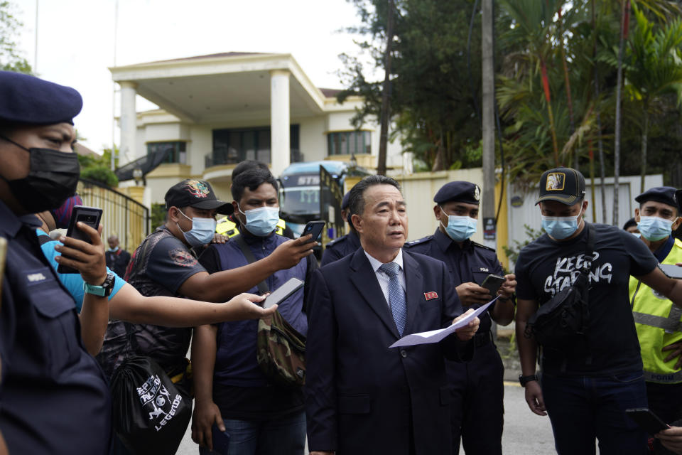 Kim Yu Song, center, a counselor at the North Korean Embassy to Malaysia, reads out a statement outside the embassy in Kuala Lumpur, Sunday, March 21, 2021. Malaysia on Friday ordered all North Korean diplomats to leave the country within 48 hours, an escalation of a diplomatic spat over Malaysia's move to extradite a North Korean suspect to the United States on money laundering charges. (AP Photo/Vincent Thian)