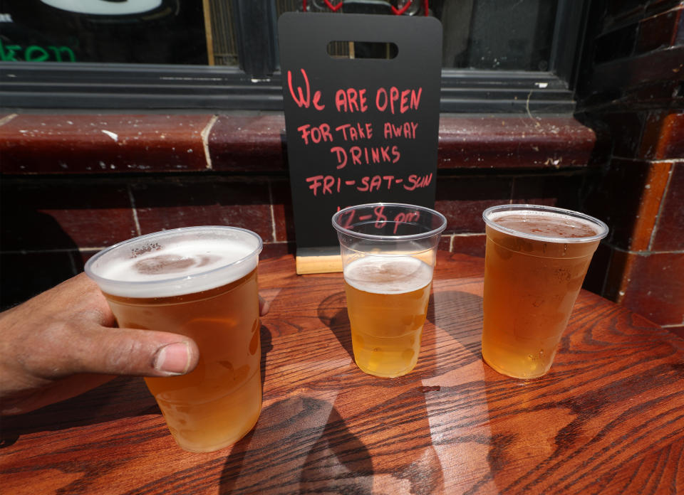 Takeaway pints of beer outside Charrington's Noted Ales And Stout pub in London, as further coronavirus lockdown restrictions are lifted in England.