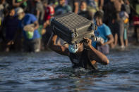 Migrants, many from Haiti, wade across the Rio Grande river from Del Rio, Texas, to return to Ciudad Acuña, Mexico, Monday, Sept. 20, 2021, to avoid deportation from the U.S. The U.S. is flying Haitians camped in a Texas border town back to their homeland and blocking others from crossing the border from Mexico. (AP Photo/Felix Marquez)