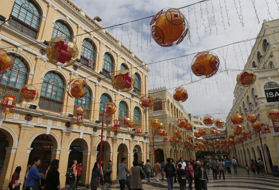 In this Feb. 1, 2014 photo, mainland Chinese tourists walk at the famous tourist spot Senado Square during a Chinese New Year celebration in Macau. The annual holiday is the busiest time of year for the former Portuguese colony, which became a special Chinese region in 1999. Many of the millions of mainland Chinese on the move during the holiday, often referred to as the world’s biggest migration, head to Macau during the festival. (AP Photo/Vincent Yu)