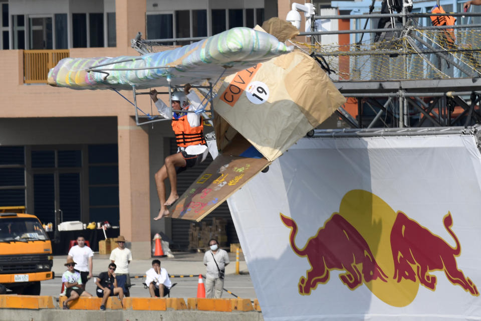 A team member jumps from a platform with a man made flying machine into the harbor in Taichung, a port city in central Taiwan on Sunday, Sept. 18, 2022. Pilots with homemade gliders launched themselves into a harbor from a 20-foot-high ramp to see who could go the farthest before falling into the waters. It was mostly if not all for fun as thousands of spectators laughed and cheered on 45 teams competing in the Red Bull “Flugtag” event held for the first time. (AP Photo/Szuying Lin)