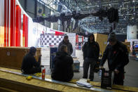 Workers stop the preparation of the 90th Geneva International Motor Show, GIMS, at Palexpo, in Geneva, Switzerland, Friday, Feb. 28, 2020. The 90th edition of the International Motor Show, scheduled to begin on March 5th, is cancelled due to the advancement of the (Covid-19) coronavirus in Switzerland. The Swiss confederation announced today that all events involving more than 1,000 people would be banned until 15 March. (Salvatore di Nolfi/Keystone via AP)