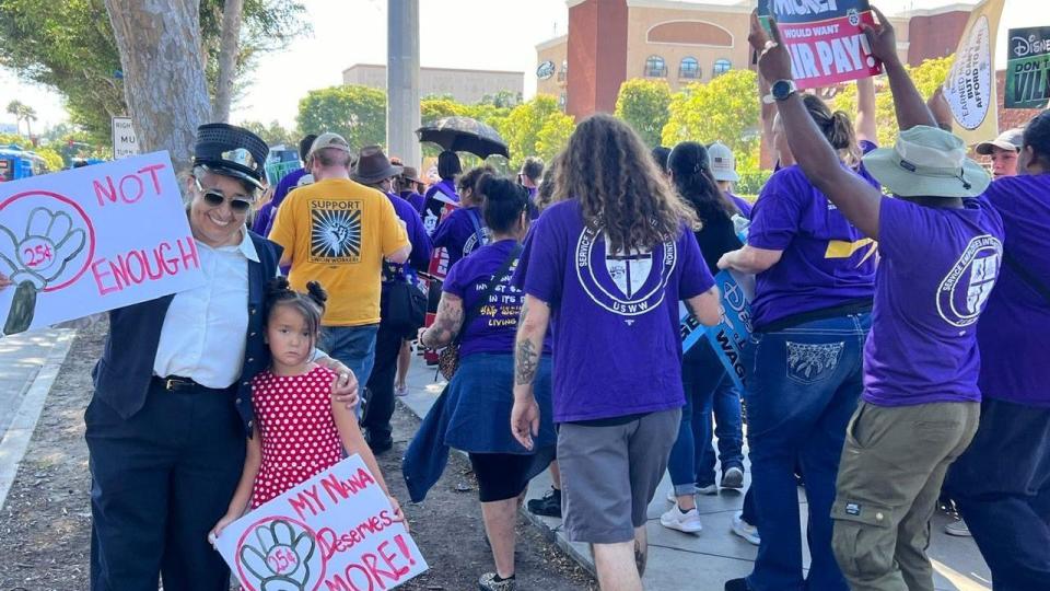 Disneyland train conductor Cecilia Quail poses with her granddaughter while protesting outside the park.  