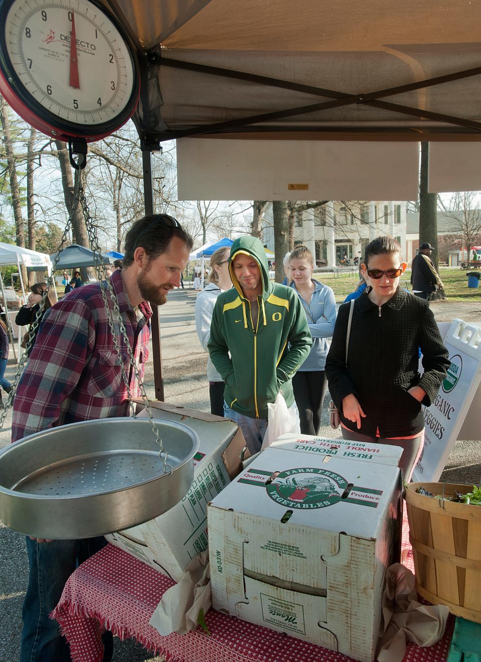 Adam Barr of Barr Farms helps Joseph and Brandi Smith of New Albany, In., pick out some produce at his Douglass Loop Farmers Market booth. Barr’s Rhodelia, Ky., farm will double its CSA base to to serve 100 consumer subscribers this summer.