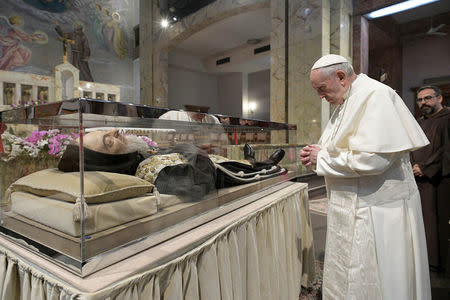 Pope Francis prays in front of the mortal remains of Saint Pio of Pietrelcina (Padre Pio) at the Santa Maria delle Grazie sanctuary in San Giovanni Rotondo, Italy March 17, 2018. Osservatore Romano/Handout via REUTERS