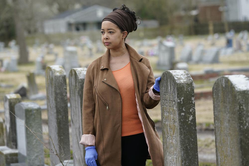 Nadia Orton, a genealogist and family historian in Virginia, poses next to tombstones at the Lincoln Memorial Cemetery in Portsmouth, Va., Tuesday, March 23, 2021. (AP Photo/Steve Helber)