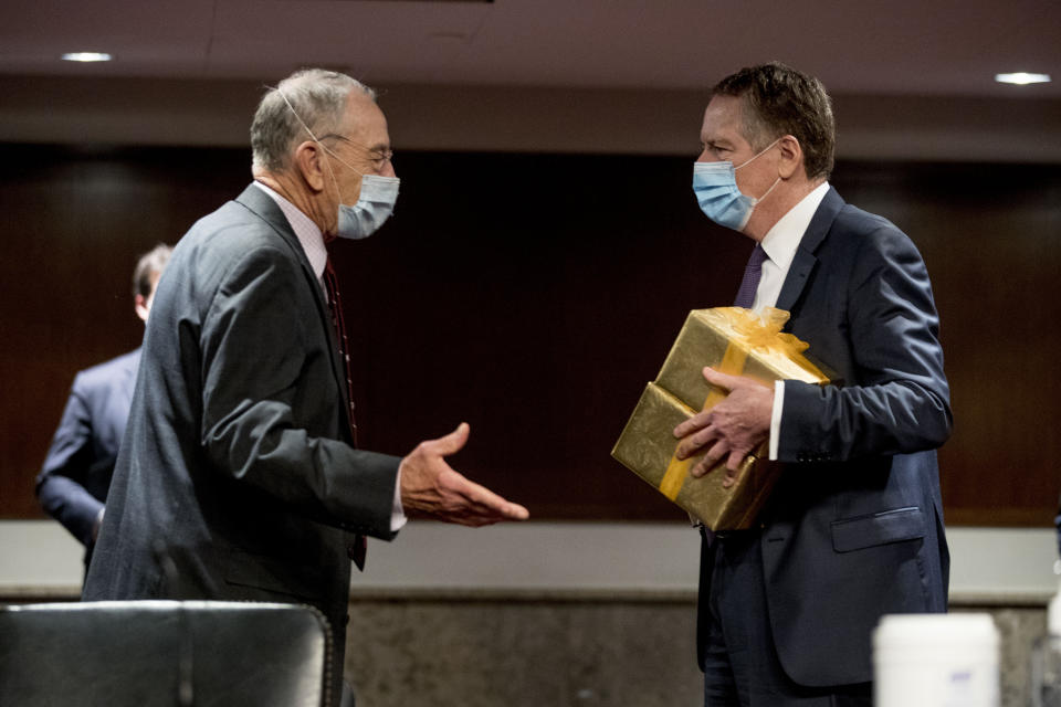 U.S. Trade Representative Robert Lighthizer arrives with gifts for Chairman Sen. Chuck Grassley, R-Iowa, left, and Ranking Member Sen. Ron Wyden, D-Ore., as he arrives at a Senate Finance Committee hearing on U.S. trade on Capitol Hill, Wednesday, June 17, 2020, in Washington. (AP Photo/Andrew Harnik, Pool)