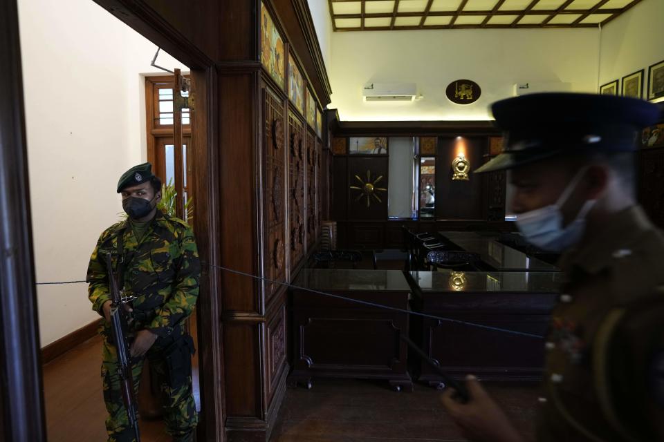 Dos policías montan guardia en la sala de gabinete de la oficina del primer ministro Ranil Wickremesinghe el jueves 14 de julio de 2022, en Colombo, Sri Lanka. (AP Foto/Eranga Jayawardena)