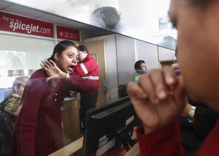 An employee of SpiceJet Airlines speaks with a passenger at the ticket counter at an airport on the outskirts of Agartala, December 17, 2014. REUTERS/Jayanta Dey/Files