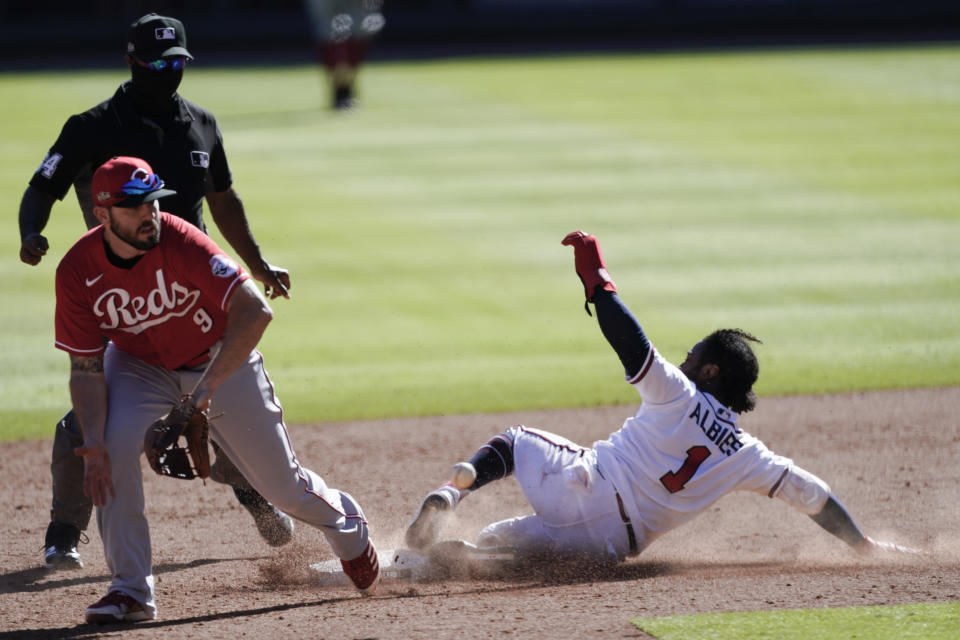 Atlanta Braves' Ozzie Albies (1) steals second base as Cincinnati Reds second baseman Mike Moustakas (9) looks on in 12th inning during Game 1 of a National League wild-card baseball series, Wednesday, Sept. 30, 2020, in Atlanta. (AP Photo/John Bazemore)