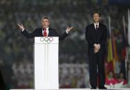 International Olympic Committee (IOC) President Thomas Bach delivers a speech next to the Governor of Jiangsu province, Li Xueyong in the rain during the 2014 Nanjing Youth Olympic Games opening ceremony, in Nanjing, Jiangsu province, August 16, 2014. REUTERS/Aly Song