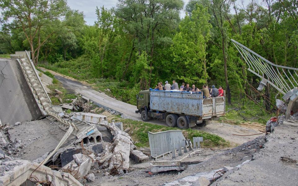 Ukrainians cross a makeshift bridge built next to a destroyed structure in Kharkiv - SERGEY KOZLOV/EPA-EFE/Shutterstock /Shutterstock 