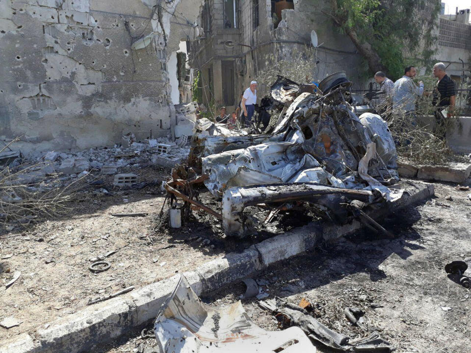 <p>This photo released by the Syrian official news agency SANA, shows people gathering at the scene of an explosion along the road to the airport in southeast Damascus, Syria, Sunday, July 2, 2017. Syrian state TV said Sunday that a series of car bomb explosions have rocked the capital, resulting in multiple casualties. (SANA via AP) </p>