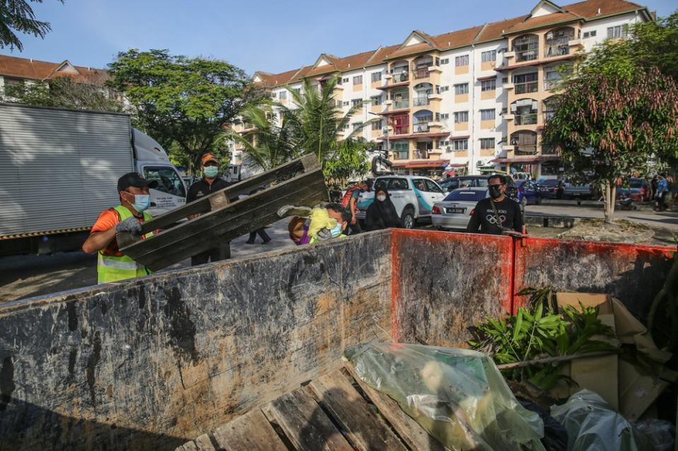 Workers clean up the area of Taman Sri Muda in Shah Alam January 8, 2022.