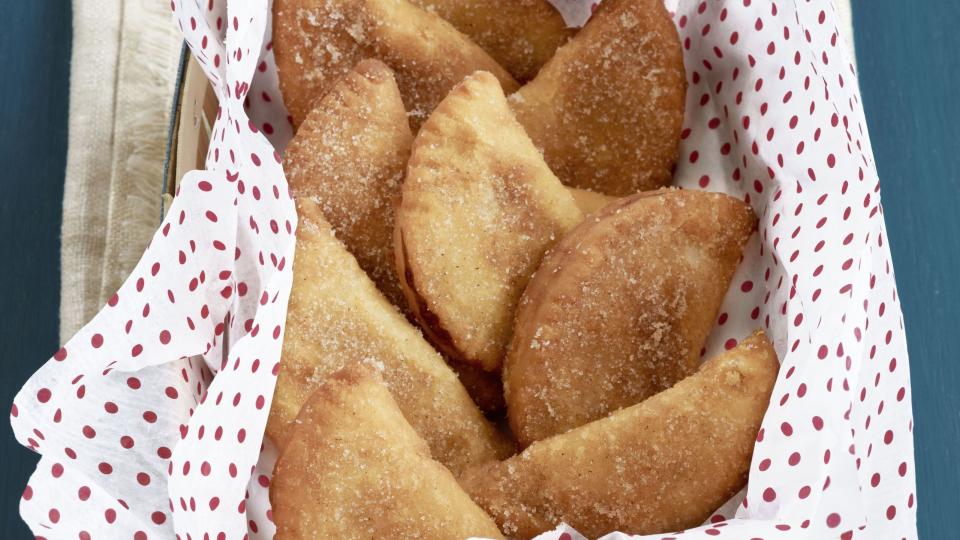 fried peach pies arranged in a parchment lined box