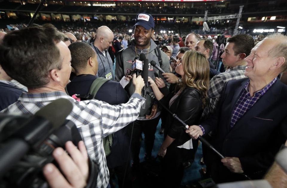 Patriots tight end Martellus Bennett (center, in hat) talks with reporters on Monday night. (AP)