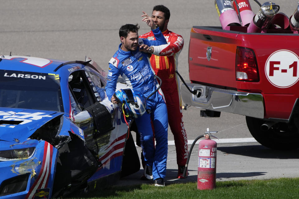 Bubba Wallace, right, pushes Kyle Larson after the two crashed during a NASCAR Cup Series auto race Sunday, Oct. 16, 2022, in Las Vegas. (AP Photo/John Locher)