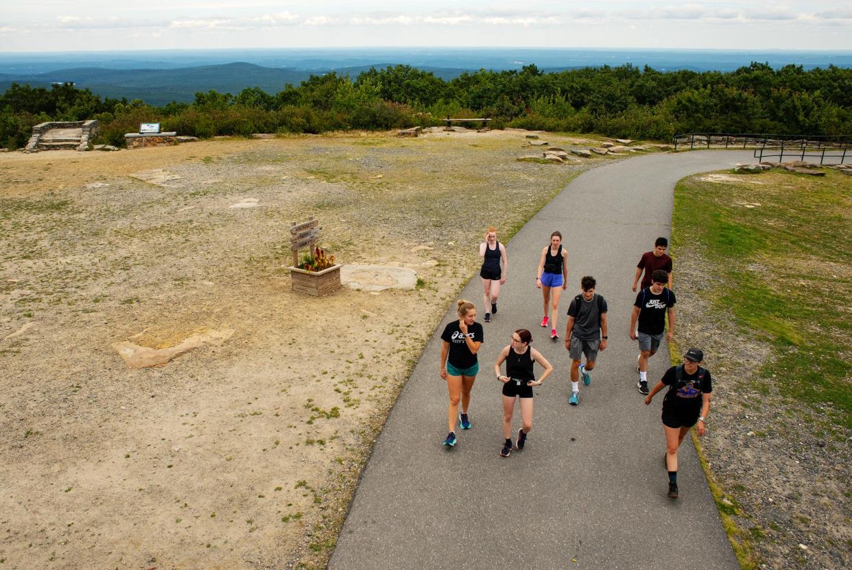 Members of the Worcester State University cross-country team reach the 2,006-foot-high summit of Wachusett Mountain Thursday. The team walked the mountain trails in the afternoon after their morning training run.