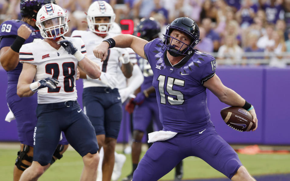 TCU quarterback Max Duggan (15) reacts after running the ball in for a touchdown as Duquesne defensive backs Spencer DeMedal (28) and Leandro Debrito (7) look on during the first half of an NCAA college football game Saturday, Sept. 4, 2021, in Fort Worth, Texas. (AP Photo/Ron Jenkins)