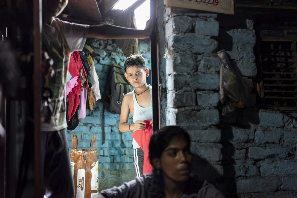 Rajkumari’s son, Rohit, changes clothes after returning from school at their home in New Delhi on Sept. 5, 2023. (Saumya Khandelwal for NBC News)