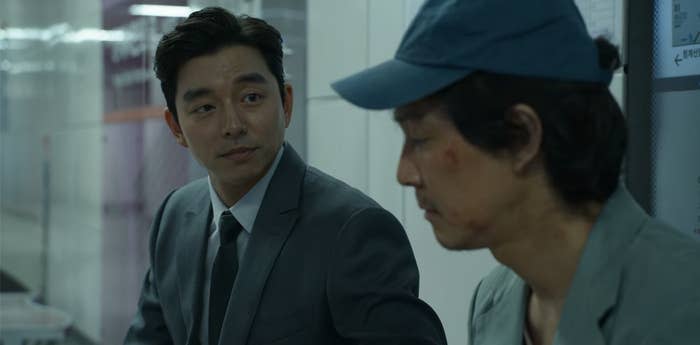 the man in the suit talking to Gi-hun