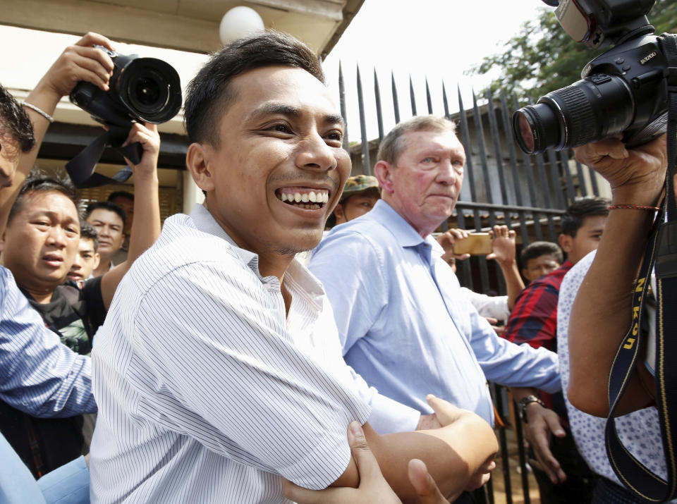 Reuters reporter Kyaw Soe Oo, left, reacts after being freed from Insein Prison in Yangon, Myanmar, Tuesday, May 7, 2019. Two Reuters journalists who were imprisoned for breaking Myanmar's Official Secrets Act over reporting on security forces' abuses of Rohingya Muslims were pardoned and released Tuesday, the prison chief and witnesses said. (Ann Wang/Pool Photo via AP)