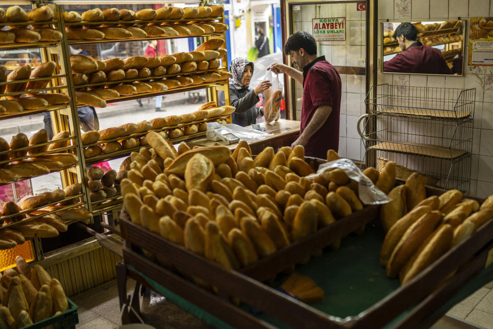 A woman buys bread in a local bakery in Balat neighbourhood, in Istanbul, Turkey, Tuesday, March 19, 2024. (AP Photo/Francisco Seco)