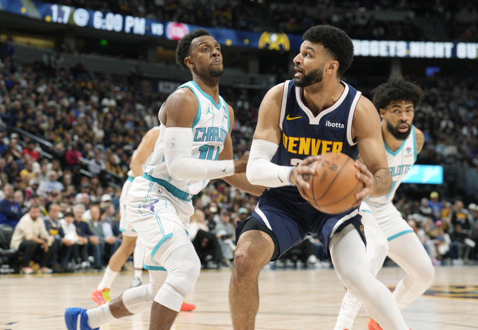 Denver Nuggets guard Jamal Murray, right, goes up for a basket as Charlotte Hornets guard Ish Smith defends in the first half of an NBA basketball game, Monday, Jan. 1, 2024, in Denver. (AP Photo/David Zalubowski)