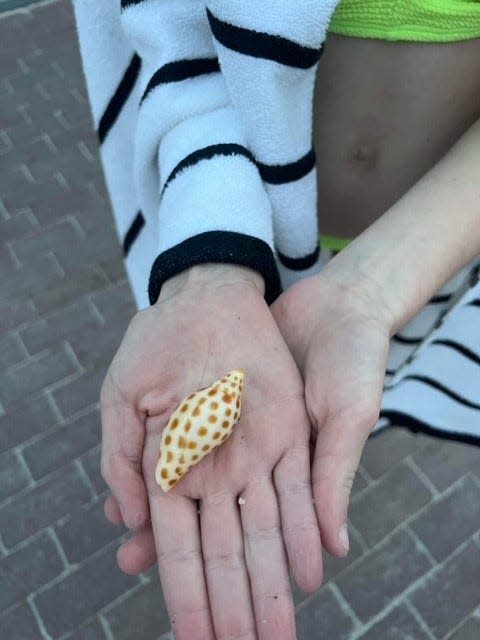 Reagan Savage holds a shell she found on the beach during her family's vacation on the island in April.