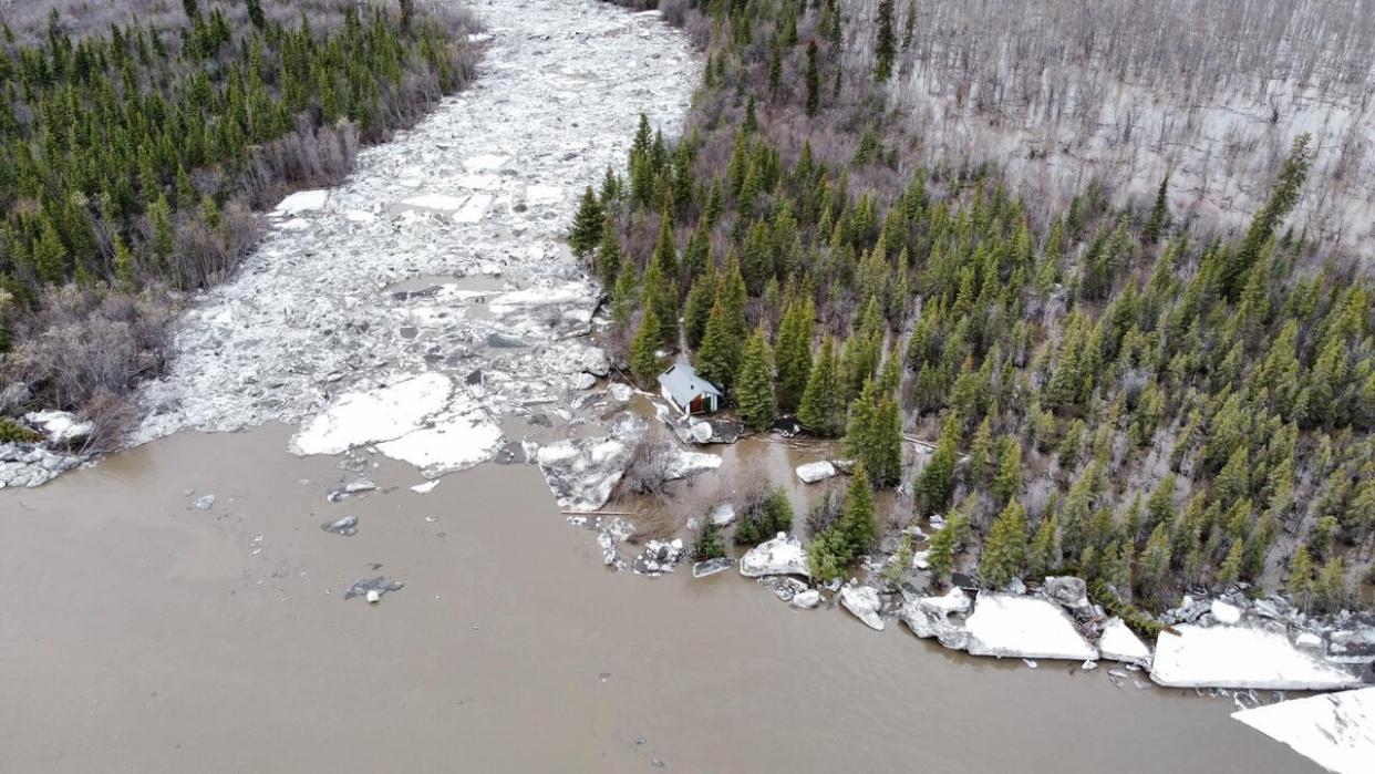 A cabin stranded in high water from the Peel River across from Fort McPherson, N.W.T. in May 2023. Water levels in the region are high this year, but a hydrologist said it's difficult to predict what that will mean yet for the region.  (Dean Charlie - image credit)