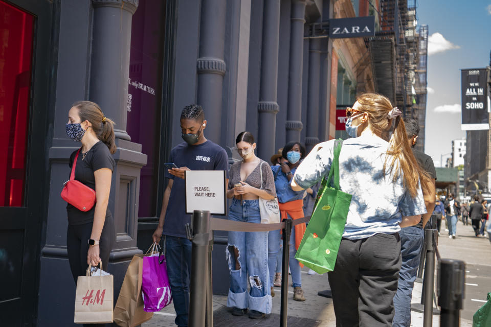 Customers wait in a line before entering a store on Broadway while wearing protective masks in the retail shopping district of the SoHo neighborhood of the Manhattan borough of New York, Friday, May 14, 2021. Gov. Andrew Cuomo has yet to say whether he will change his state’s mask mandate in light of new federal guidance that eases rules for fully vaccinated people. (AP Photo/John Minchillo)