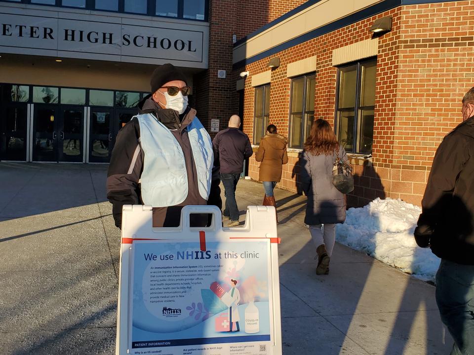 Portsmouth resident and volunteer Ron Fitz helps direct people coming into Exeter High School as part of the second COVID-19 Booster Blitz event Saturday, Jan. 8, 2022.