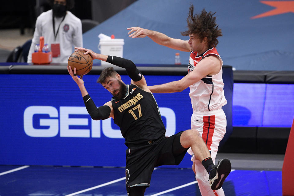 Memphis Grizzlies center Jonas Valanciunas (17) and Washington Wizards center Robin Lopez (15) battle under the basket during the second half of an NBA basketball game, Tuesday, March 2, 2021, in Washington. (AP Photo/Nick Wass)