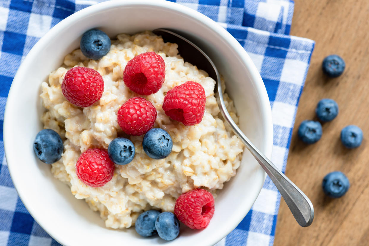 Oatmeal porridge with fresh berries, raspberry and blueberry. Closeup view, top view. Healthy eating, healthy breakfast, nutrition concept