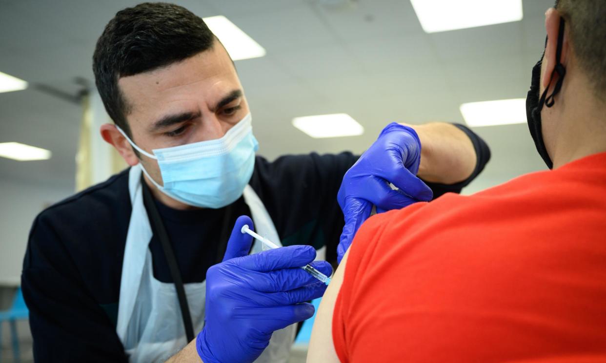 <span>A man receives his Covid-19 booster at the Sir Ludwig Guttmann health and wellbeing centre in Stratford, east London.</span><span>Photograph: Leon Neal/Getty Images</span>
