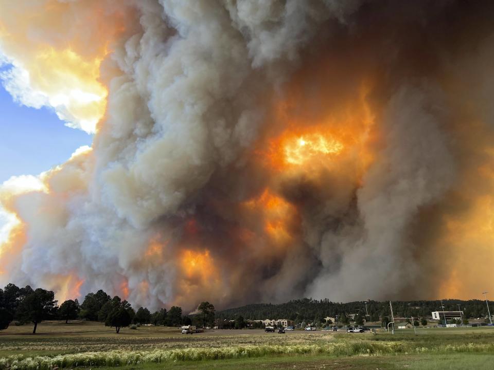 In this photo provided by Pam Bonner, smoke rises from fires in Ruidoso, N.M., Monday, June 17, 2024. Thousands of southern New Mexico residents fled the mountainous village as a wind-whipped wildfire tore through homes and other buildings. (Pam Bonner via AP)