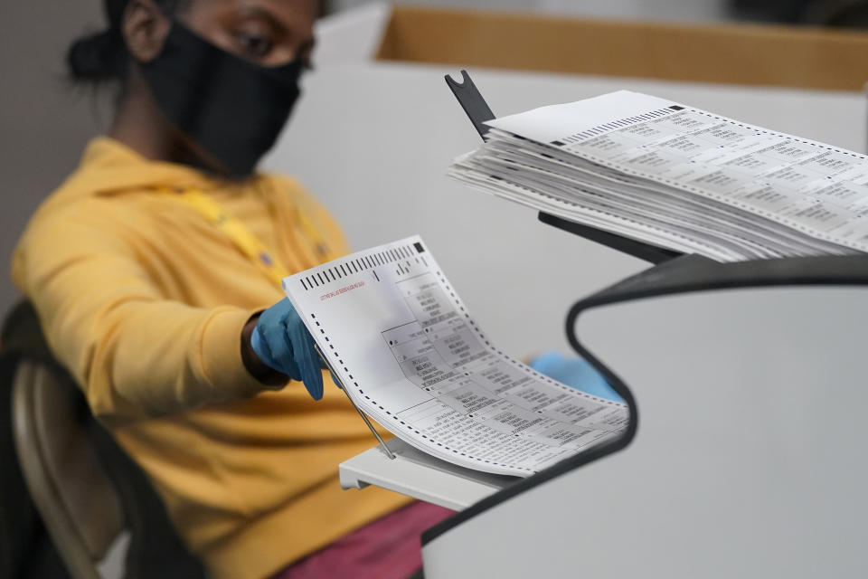 FILE - In this Nov. 5, 2020, file photo a county election worker scans mail-in ballots at a tabulating area at the Clark County Election Department in Las Vegas. County officials in Nevada began signing off Monday, Nov. 16 on results of the Nov. 3 election that gave Democratic candidate Joe Biden a 33,596-vote statewide victory over Republican Donald Trump in the presidential contest. The former vice president drew a little over 50% of the vote and Trump a little under 48% in unofficial results submitted for approval by commissioners in counties including Washoe, surrounding Reno, and Clark, which encompasses Las Vegas. (AP Photo/John Locher, File)