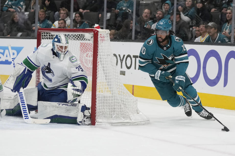 San Jose Sharks left wing Anthony Duclair (10) skates with the puck next to Vancouver Canucks goaltender Casey DeSmith during the first period of an NHL hockey game in San Jose, Calif., Saturday, Nov. 25, 2023. (AP Photo/Jeff Chiu)