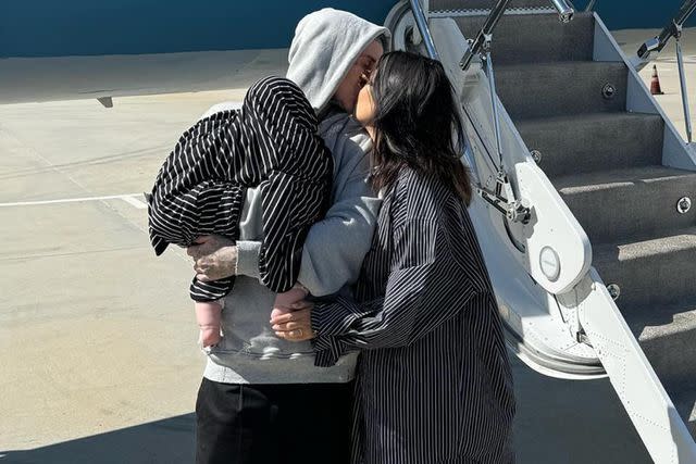 <p>Travis Barker/Instagram</p> Travis Barker kisses Kourtney Kardashian while holding their son Rocky.