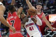 Detroit Pistons forward Saddiq Bey (41) runs into the defense of Chicago Bulls forward Troy Brown Jr. (7) and guard Alex Caruso during the first half of an NBA basketball game, Wednesday, Oct. 20, 2021, in Detroit. (AP Photo/Carlos Osorio)