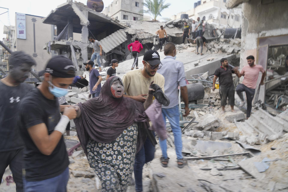 Palestinians evacuate survivors after the Israeli bombardment of the Gaza Strip in Deir Al-Balah, Sunday, Oct. 22, 2023. (AP Photo/Hatem Moussa)