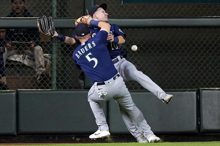 Seattle Mariners left fielder Jake Bauers (5) collides with center fielder Jarred Kelenic (10) while trying to catch a fly ball by Houston Astros' Michael Brantley during the fifth inning of a baseball game Tuesday, Sept. 7, 2021, in Houston. Kelenic was charged with an error on the play. (AP Photo/David J. Phillip)