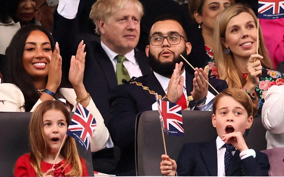 Prince George and Princess Charlotte, who wave Union flags during Saturday’s Party at the Palace - Henry Nicholls/Reuters