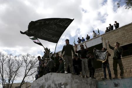 Protesters carry Al-Qaeda flags during an anti-government protest after Friday prayers in the town of Marat Numan in Idlib province, Syria, March 11, 2016. REUTERS/Khalil Ashawi