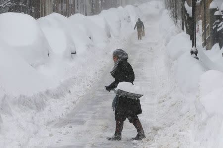 A woman shovels snow on Joy Street during a winter blizzard in Boston, Massachusetts February 15, 2015. REUTERS/Brian Snyder
